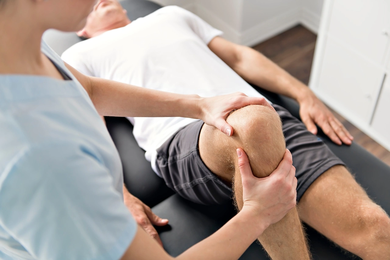 Physical therapist treating a patient's knee